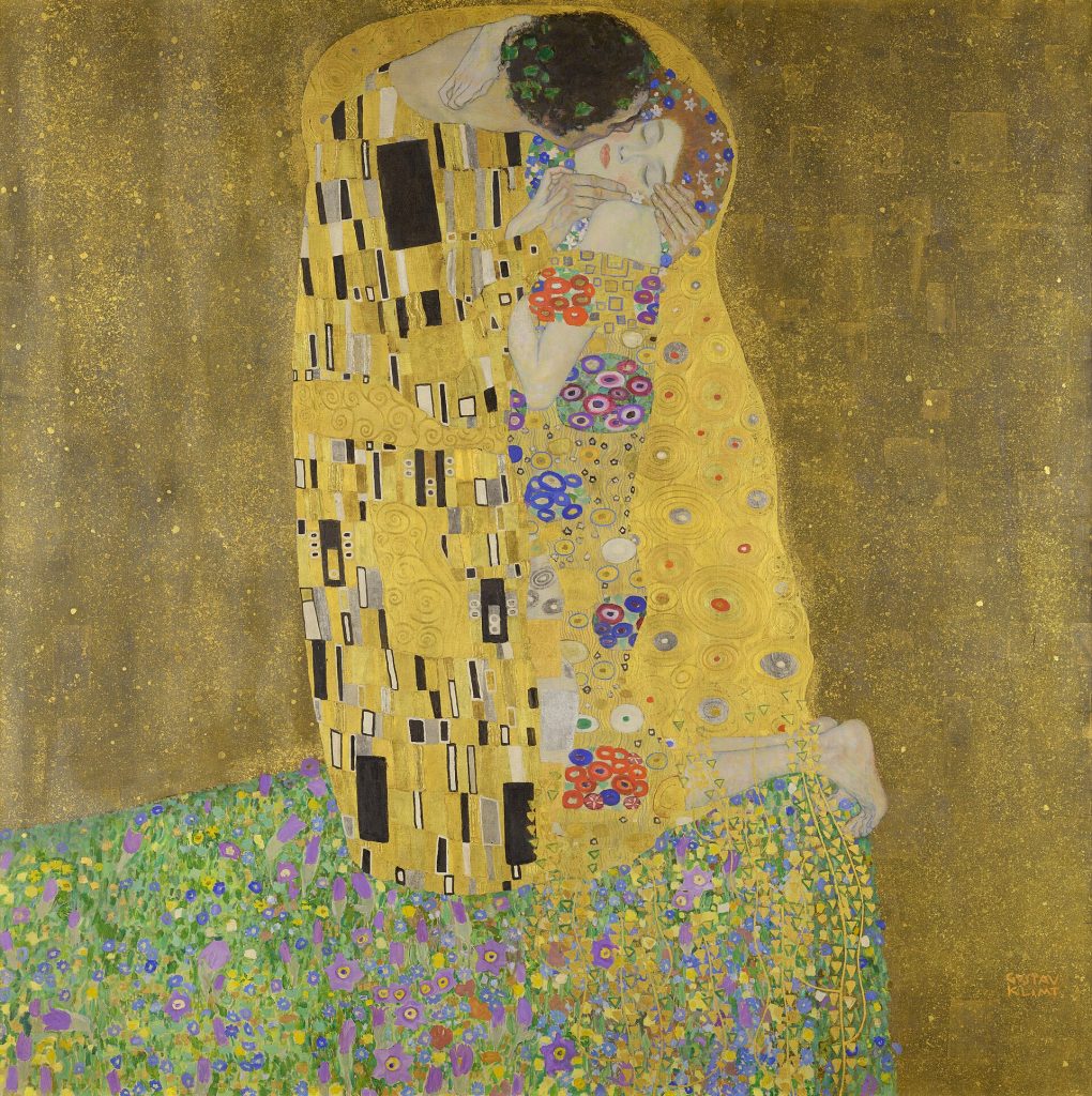 Couple wrapped in gilded robes embracing on a flowering meadow